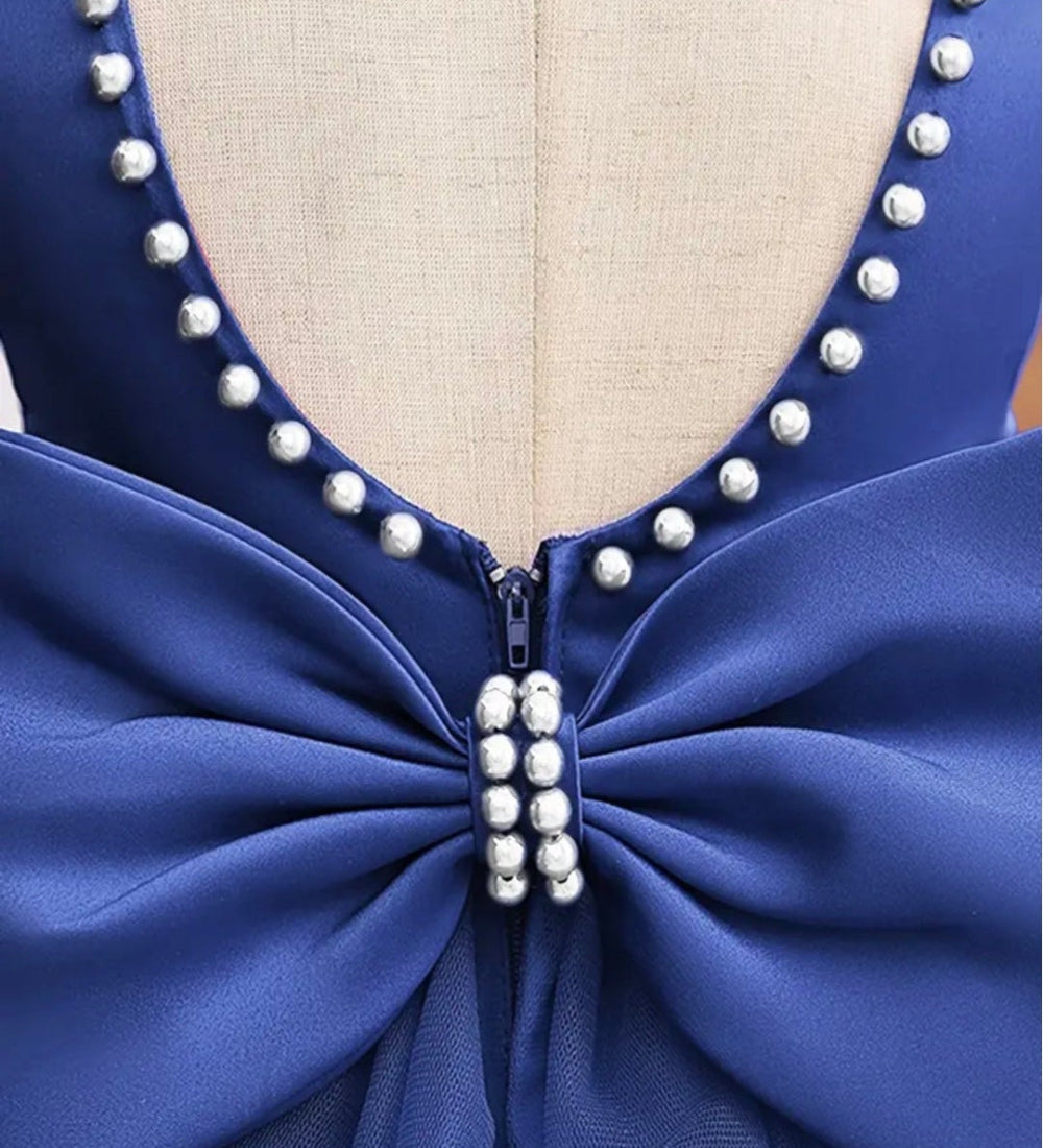 Avondjurk. Mouwloos met wijde tule rok. Hierin is je kindje een prinsesje! Met mooie pareltjes aan de hals en een wijde rok met grote strik.