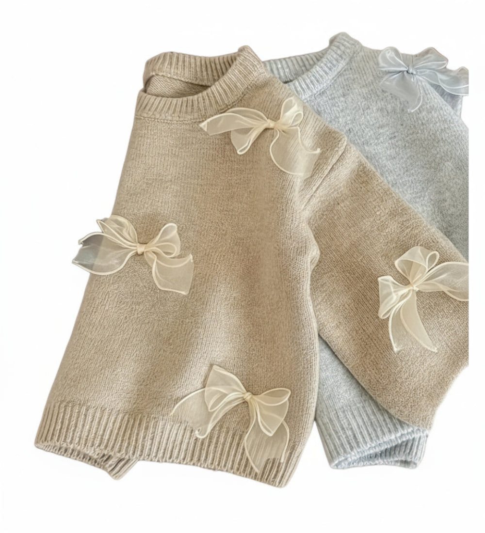 trui in beige of lichtgrijs met tule strikjes. Heel zacht materiaal.