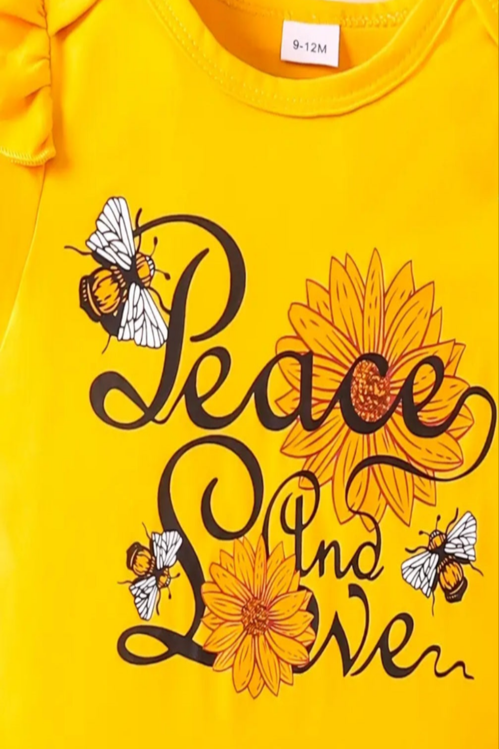 Body geel "Peace and love" en zwarte broek met zonnebloem en wijde pijpen (eventueel  te combineren met gele schoentjes/ gympjes)