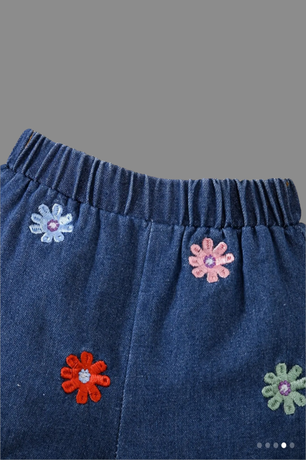 jeansshort met zwart t-shirt met bloemen. Leuk te combineren met de zwarte gymp met bloemetje.