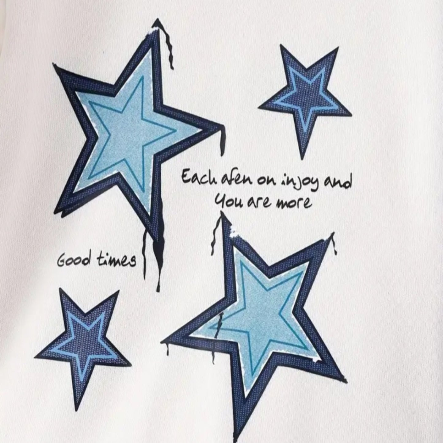 witte trui met blauwe sterren met mooi bewerkte mouwen  en jeans met strikjes en wijde pijpen