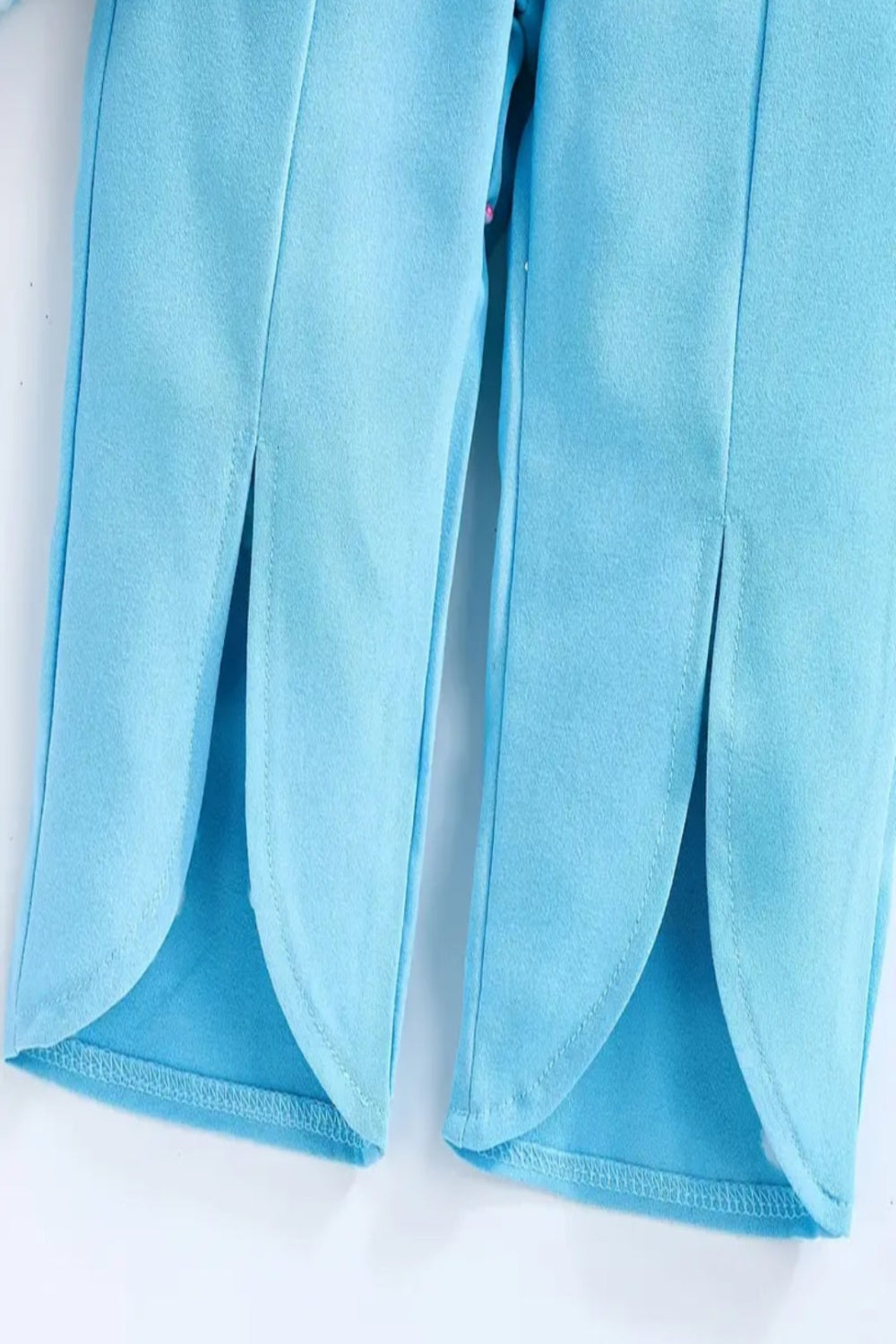 Top lichtblauw met rode bloemen en lichtblauwe broek met split aan onderzijde pijp  (te combineren met de rode schoentjes))